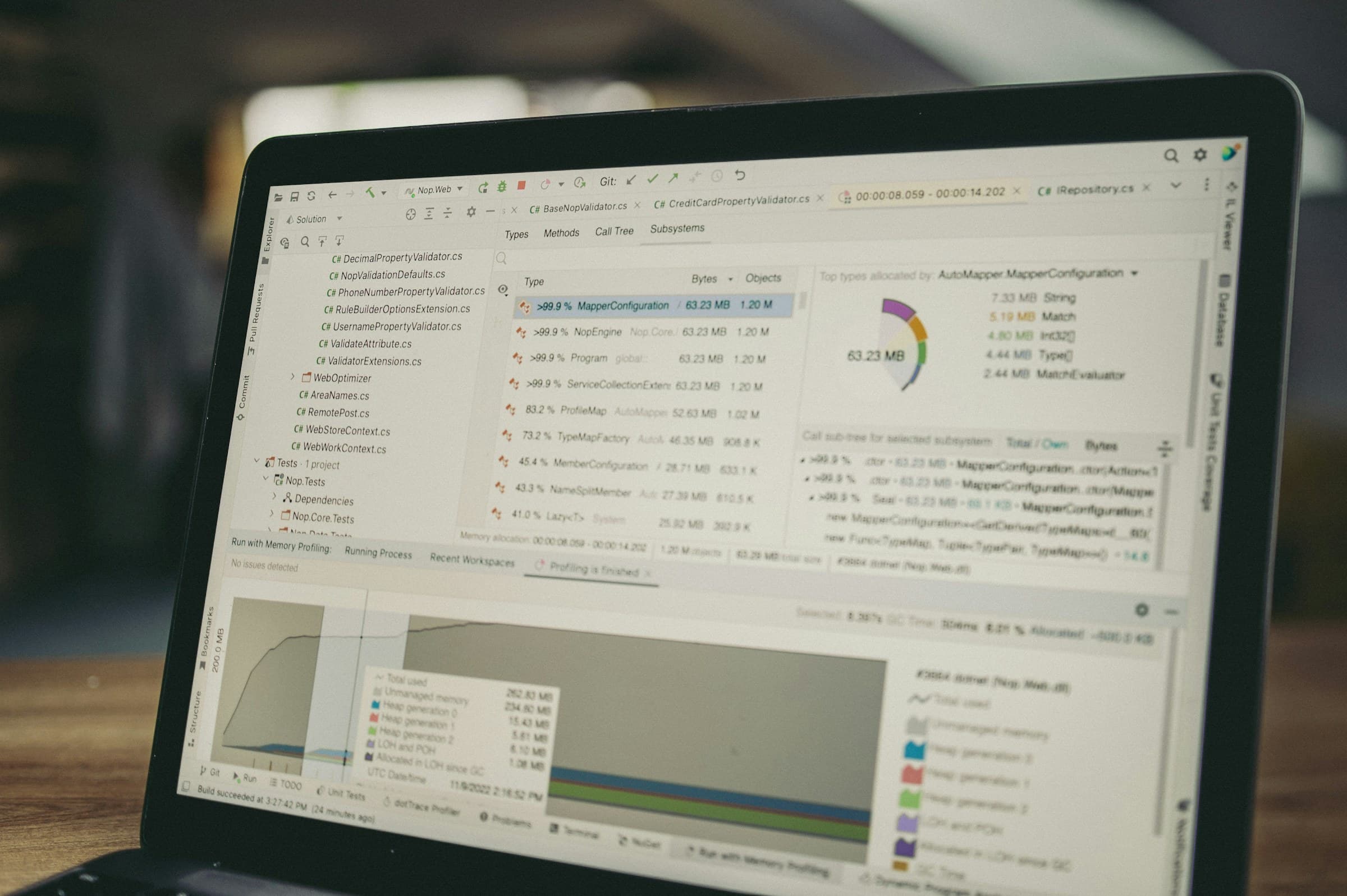 A laptop displaying source code and analytical charts during a software-development workflow