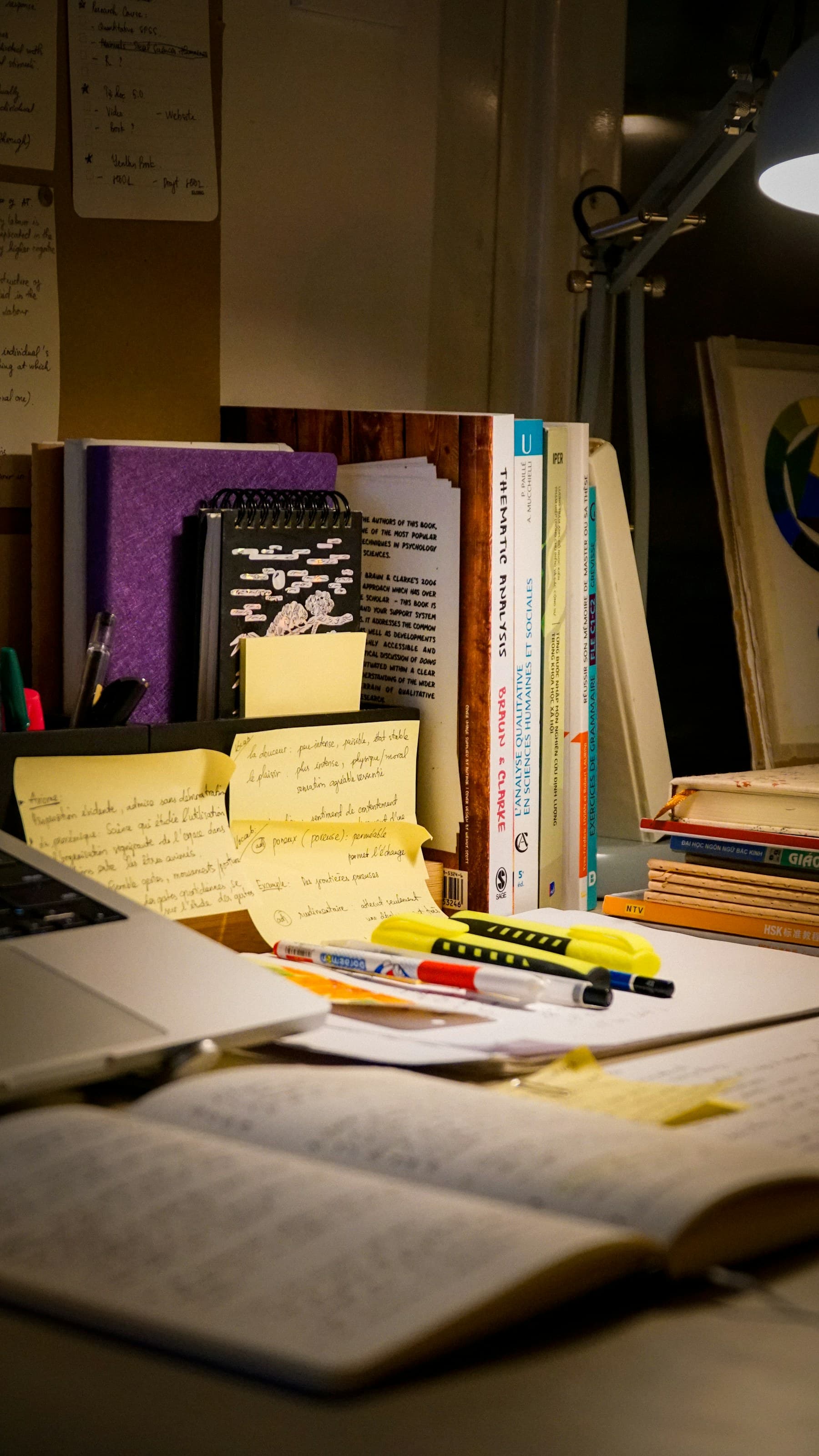 Research books, handwritten notes and documents arranged across a working desk